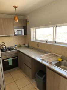 a kitchen with a sink and a counter top at Oceanica Departamento in Iquique
