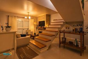 a staircase in a living room with a couch and a living room at Casa grande e aconchegante in Encantado