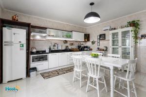 a kitchen with white appliances and a table and chairs at Casa grande e aconchegante in Encantado