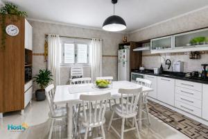 a kitchen with a white table and chairs at Casa grande e aconchegante in Encantado