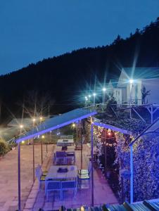 a patio with tables and chairs at night at Shivpur Greens in Mashobra