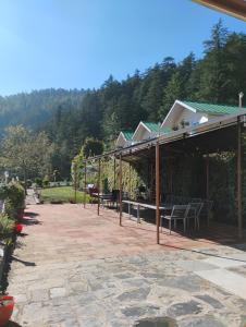 a patio with a table and chairs on it at Shivpur Greens in Mashobra