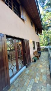 a house with sliding glass doors and a patio at Villaggio Farnese in Campos do Jordão
