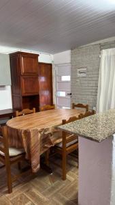 a dining room with a wooden table and chairs at BRISAN descanso sol,y playa in Barra del Chuy