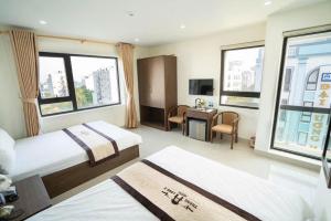 a hotel room with two beds and a desk at Khách Sạn Thăng Long 2 in Sầm Sơn