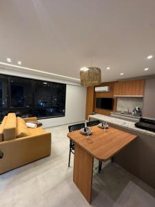 a kitchen and living room with a couch and a table at Carneiros Pernambuco in Tamandaré