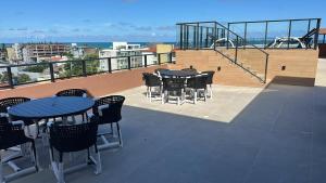 a patio with tables and chairs on a balcony at Carneiros Pernambuco in Tamandaré