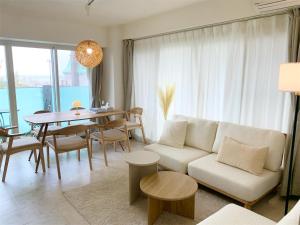 a living room with a white couch and a table at O2 capsule house OTARU in Otaru
