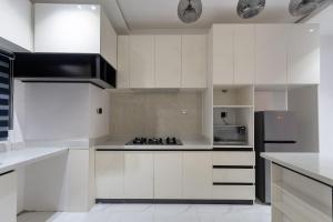 a kitchen with white cabinets and a black refrigerator at Modern Luxury 2BR Spacious Cozy 24hr Power in Lekki