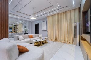 a living room with a white couch and a tv at Modern Luxury 2BR Spacious Cozy 24hr Power in Lekki