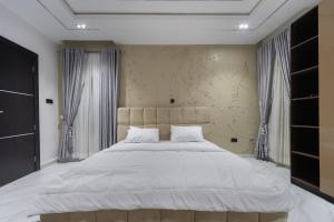 a bedroom with a large bed with white sheets at Modern Luxury 2BR Spacious Cozy 24hr Power in Lekki +26 photos