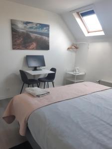 a bedroom with a bed and a desk with a computer at B&B Casa Mama in Brugge in Bruges