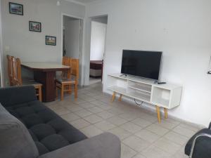 ein Wohnzimmer mit Sofa und Flachbildfernseher in der Unterkunft Bate & Volta - Apartamentos com 2 quartos próximo ao SESC Bertioga in Bertioga + 10 Fotos