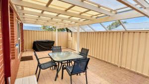 a patio with a glass table and chairs on it at Escape to 39 at Cape View in Busselton