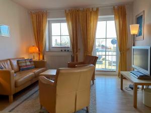 a living room with a couch and a tv at Ferienwohnung in Orth auf Fehmarn in Orth +3 photos