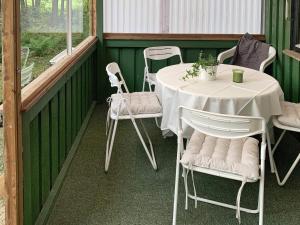 a porch with two tables and white chairs on it at 6 person holiday home in Ucklum-By Traum in Ucklum +8 photos