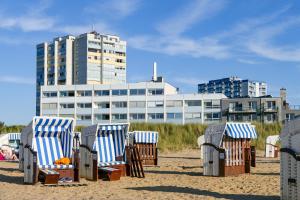 a group of chairs on a beach with a building at Am Sahlenburger Strand AS05 in Cuxhaven