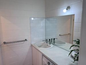 a white bathroom with two sinks and a mirror at 28 Ozone Victor Harbor in Victor Harbor +30 photos