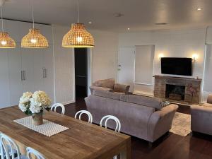 a living room with couches and a table and a television at 28 Ozone Victor Harbor in Victor Harbor