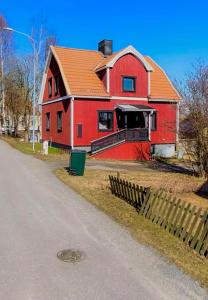 a red house with a red roof next to a road at Spacious House for Families & Workers in Skelleftehamn
