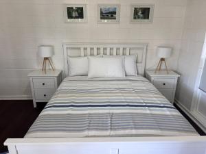 a bedroom with a bed with two nightstands and two lamps at 28 Ozone Victor Harbor in Victor Harbor