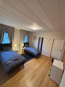 a bedroom with two beds and a couch in it at Spacious House for Families & Workers in Skelleftehamn