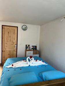 a bedroom with two swans on a blue bed at Instant Locatif in Gourbeyre