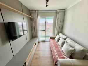 a living room with a couch and a flat screen tv at Apartamento com vista Jd Higienopolis in Bauru