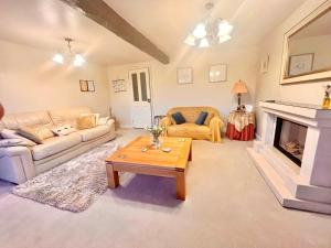 a living room with a couch and a fireplace at Tilly Cottage - overlooking Pendle Hill in Barrowford