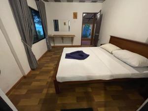 a bedroom with a bed with a blue shirt on it at Coconut Beach in Bentota