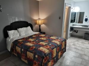a bedroom with a bed and a bathroom with a sink at Chaparral Inn in Arcola