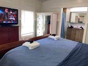 a bedroom with two towels on a bed with a tv at Beaufort SC New Renovation, Close to Parris Island, Historic Downtown, Beautiful Beaches, Sleeps 6 in Beaufort