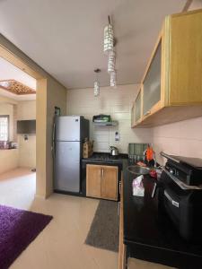 a kitchen with a refrigerator and a sink in it at Route Agafay in Aït Ali