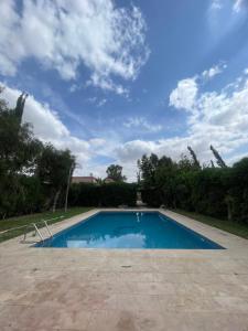 a swimming pool in a yard with a cloudy sky at Route Agafay in Aït Ali +13 photos