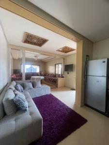a large living room with a couch and a refrigerator at Route Agafay in Aït Ali