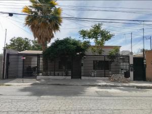 a building with a gate and a palm tree at Casa en La zona Centro de la Ciudad in Ciudad Juárez