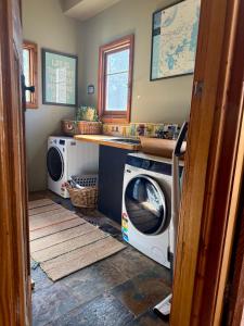 a laundry room with a washer and a washing machine at CIRQUE 5 - Alpine Lodge built around a ski lift tower in Merrijig