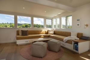 a living room with a couch and some windows at Cottage Three - Hidden Gem on Hanalei River in Hanalei