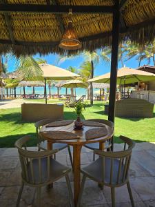 a wooden table and chairs with a view of the beach at Hotel Velejar in Cumbuco