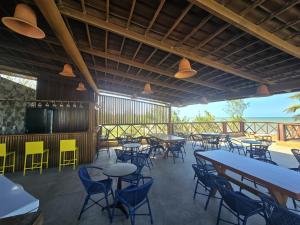 a restaurant with tables and chairs and a television at Hotel Velejar in Cumbuco