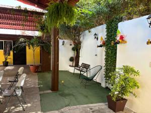 a patio with chairs and trees and plants at Hotel Luxi in Playa Azul