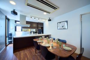 a dining room and kitchen with a wooden table and chairs at TOMARIE Rooftop House Skytree in Tokyo