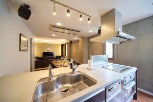 a kitchen with a sink and a living room at TOMARIE Rooftop House Skytree in Tokyo +15 photos