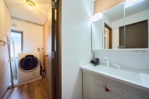 a bathroom with a sink and a washing machine at TOMARIE Rooftop House Skytree in Tokyo