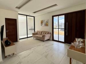 a living room with a couch and a table at Casa com Piscina - Condomínio - Próx a Praia in Marechal Deodoro