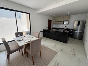 a kitchen and dining room with a table and chairs at Casa com Piscina - Condomínio - Próx a Praia in Marechal Deodoro