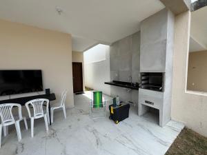 a kitchen with a table and chairs and a television at Casa com Piscina - Condomínio - Próx a Praia in Marechal Deodoro
