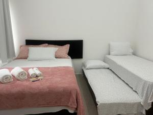 a bedroom with two beds with towels on it at Casa com Piscina - Condomínio - Próx a Praia in Marechal Deodoro +63 photos