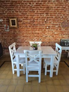 a white table and chairs in front of a brick wall at El depto de Bowie in Santa Rosa de Calamuchita