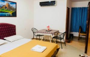 a room with a table and a bed and a table and chairs at ROYAL INN in Trivandrum
